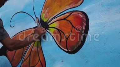 墙画家在混凝土墙上画一只蝴蝶。 时间间隔